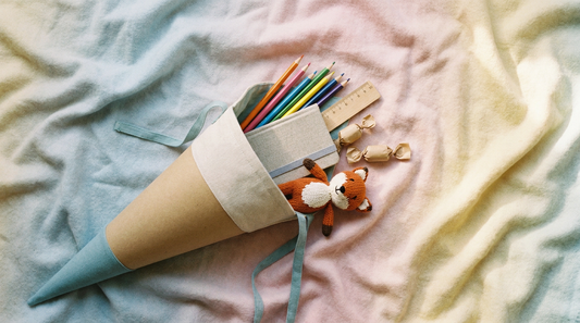 Selbst gebastelte Schultüte gefüllt mit bunten Stiften, Lineal und kleinen Geschenken